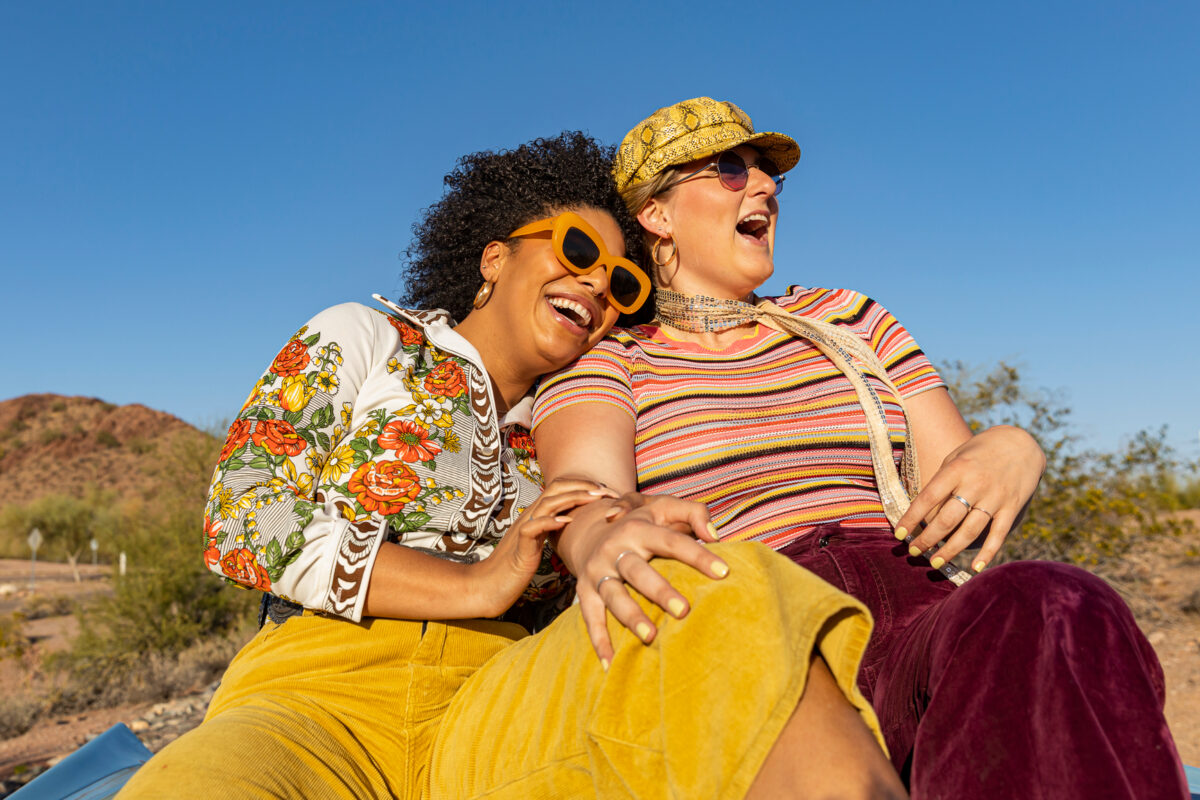 Fun Friends hugging together  in back of Vintage car on Road trip