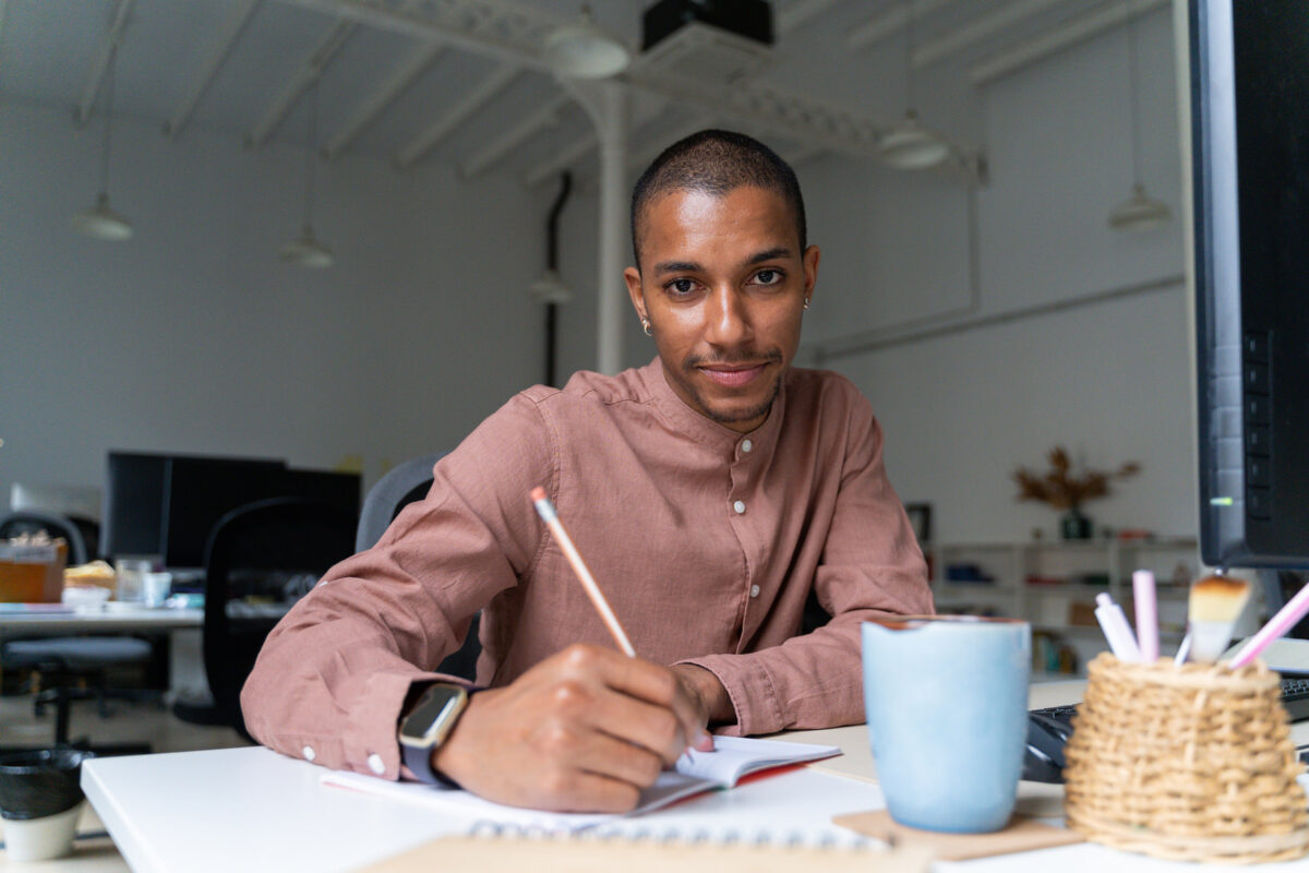 Portrait of queer LGBTIQ Stylish Man working in office